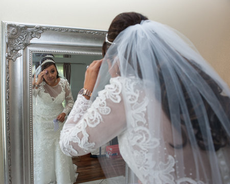 Latina bride checking details in the mirror.