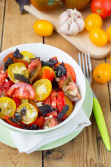 salad of colorful tomatoes on a wooden background