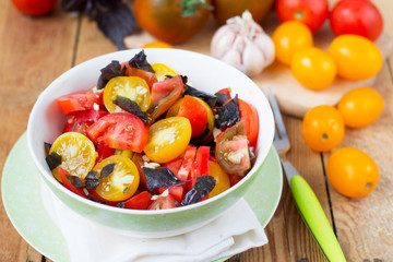 salad of colorful tomatoes on a wooden background