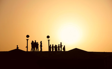 Silhouettes of people in the desert at sunset, hiking