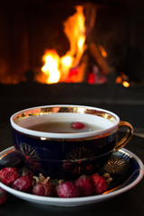 Rosehip tea in front of roaring fire in a fire place