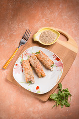 salmon rolled up with sesame seeds ricotta and arugula