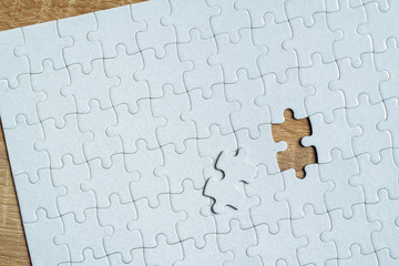 Piece missing from jigsaw puzzle on wooden table