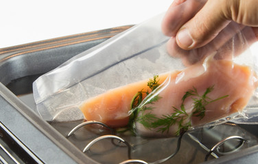 Fresh chicken breast prepared under vacuum is putting in the water;  sou vide - cooking under vacuum