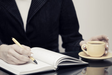 Business woman writing in notebook