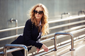 Young fashion business woman in sunglasses on the city street