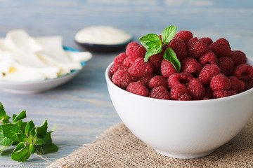 A white bowl with fresh raspberries