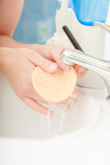 Woman washing hands under flowing tap water