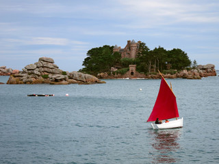 White boat with red sail infront of old castle, Brittany, France