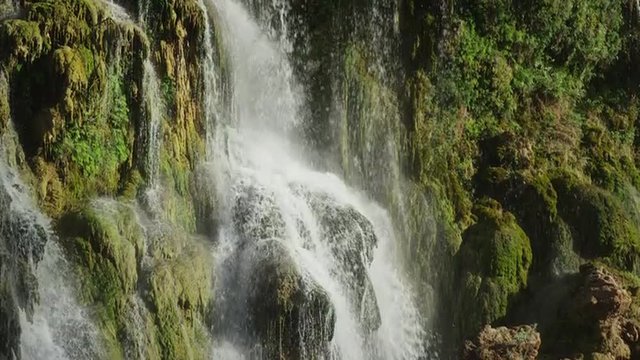 Wide slow motion panning shot of waterfall in rocky landscape / Havasupai, Arizona, United States