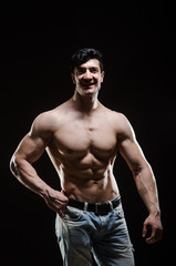 Fototapeta premium Muscular man posing in dark studio