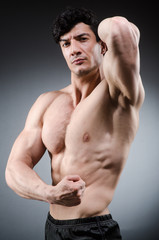 Muscular man posing in dark studio