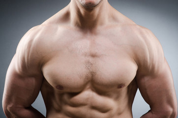 Fototapeta premium Muscular man posing in dark studio