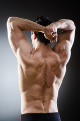 Obraz na płótnie Canvas Muscular man posing in dark studio