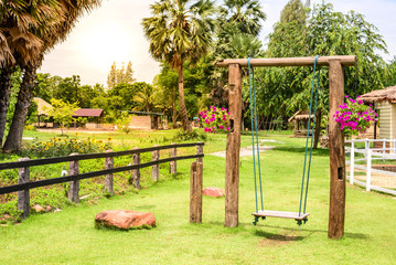 Vintage wooden swing in garden.