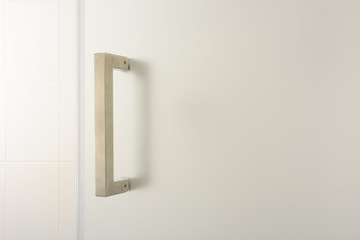 Silver bathroom door handle on opaque glass
