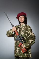 Soldier with handgun against gray