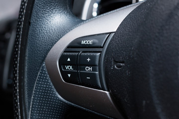 Audio control buttons on the steering wheel of a modern car
