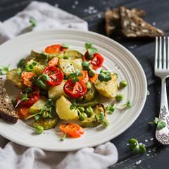 roasted vegetables on a white plate on a dark wooden background
