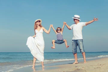 Happy family walking on the beach at the day time.