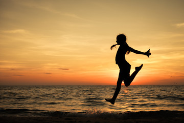 Fototapeta na wymiar Happy teen girl jumping on the beach
