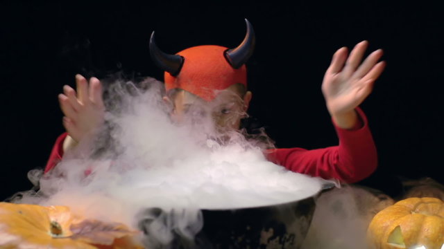 Little devil casting a spell over boiling potion 