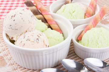 Ice cream with waffle stick in white bowls.