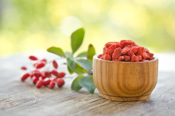 berberries and goji berries isolated on wooden table.