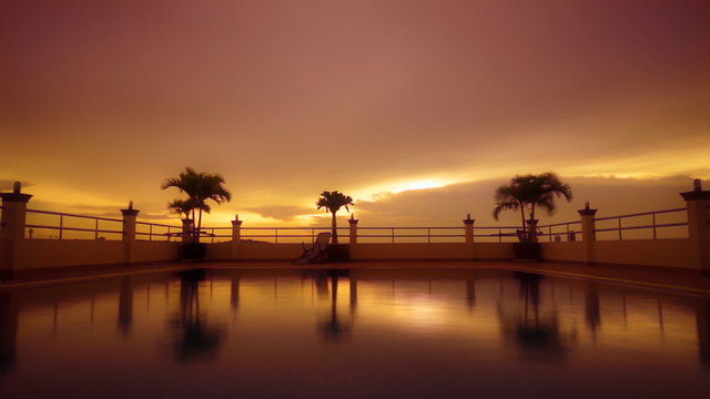 Golden sunset reflected in rippled swimming pool water. Timelapse FullHD 1080p.