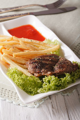 Hot beef steak with french fries and ketchup close-up. vertical
