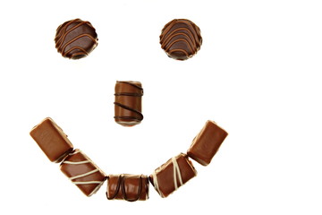 Smile from tasty chocolates candies on white background