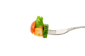a piece of fried meat with vegetables on a fork isolated on a white background