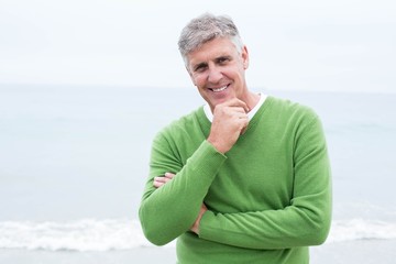 Fototapeta na wymiar Smiling man standing at the shoreline