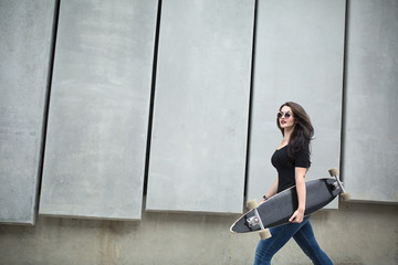 Stylish teenager girl with a longboard