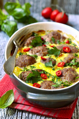 Meatballs baked in omelet.