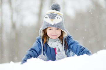 Fototapeta na wymiar Funny little girl having fun in winter park