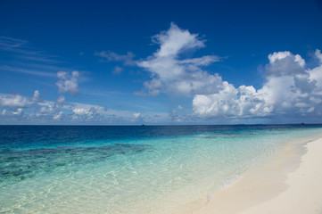Fototapeta na wymiar Beautiful turquoise ocean, sand beach and cloudy sky