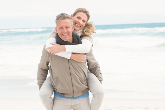 Smiling Man Giving Woman A Piggy Back