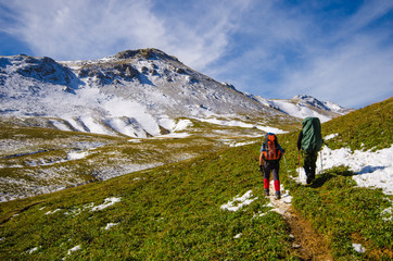 Fototapeta premium Two tourists with backpacks go to the mountains.