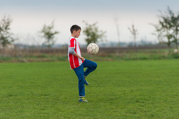 Boy kicking football