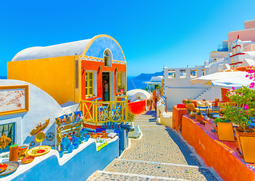 Fototapeta Typical colorful narrow street in Oia the most beautiful village of Santorini island in Greece