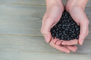 Woman showing handful of black beans