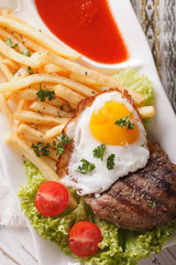 Fried potatoes, egg, grilled beefsteak with ketchup macro. vertical 
