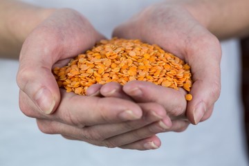 Woman showing handful of red lentils
