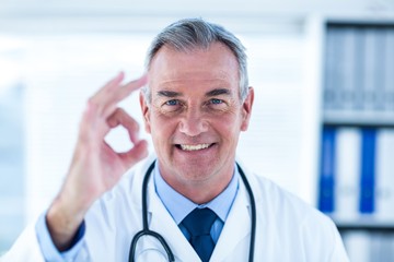 Portrait of male doctor showing ok sign in clinic