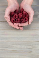 Woman showing handful of raspberries