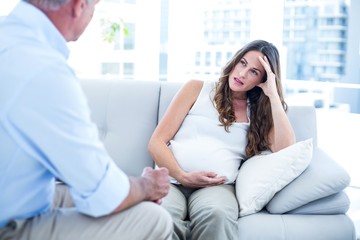 Depressed preganant woman talking with therapist