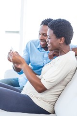 Fototapeta premium Couple smiling while looking at photo