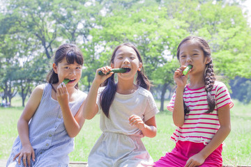 Obraz premium きゅうりを食べる小学生