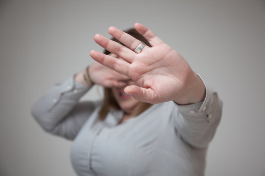 Woman covering her face and saying stop